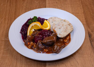 Mittagessen für Firmen mit hochwertigen Lebensmitteln und einfacher Zubereitung - Beispielbild: Hirschgulasch mit Serviettenknödel und Rotkraut